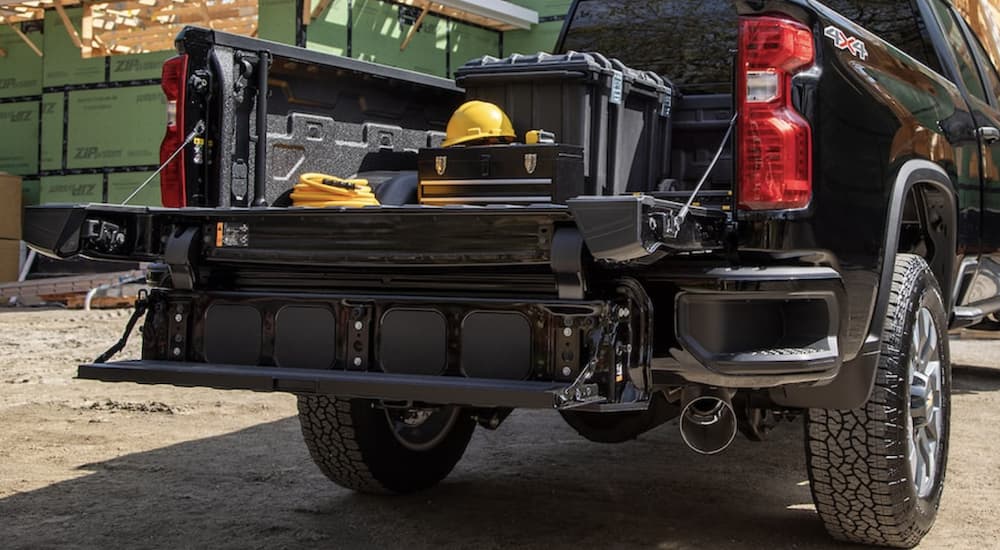A black 2022 Chevy Silverado 2500 HD is shown from the rear at a construction site.