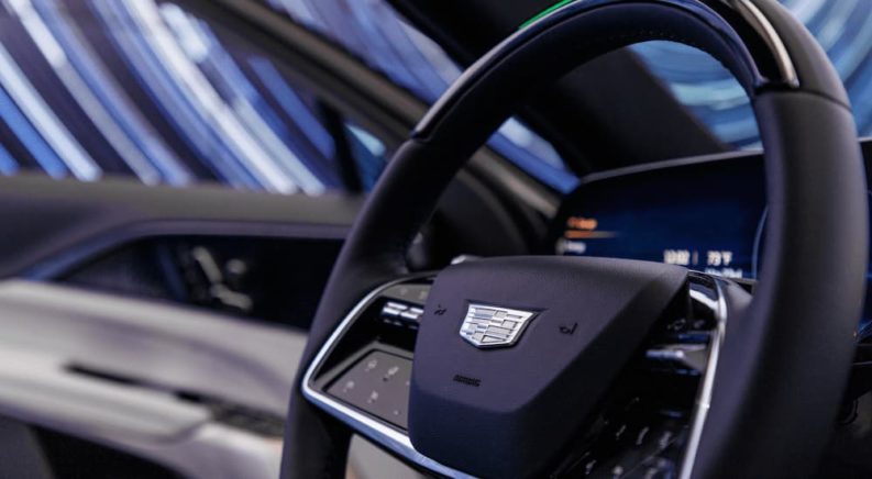 A close up of the black and silver accented steering wheel of a 2023 Cadillac LYRIQ is shown.