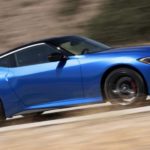 A blue 2023 Nissan Z is shown from the side driving on an open road.