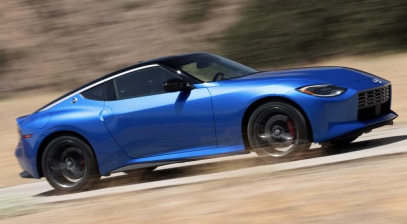 A blue 2023 Nissan Z is shown from the side driving on an open road.