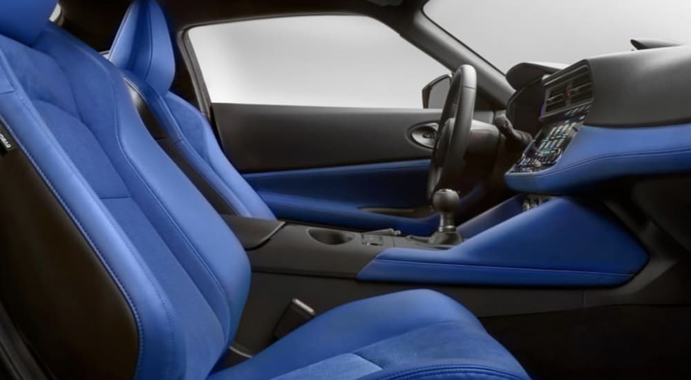 The blue and black interior of a 2023 Nissan Z shows the front seats and steering wheels.