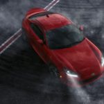 A red 2022 Toyota GR 86 is shown from a high angle driving on a track.