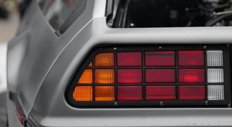 A close up shows the driver side taillight on a silver 1982 DMC Delorean after leaving a Chevy dealer.