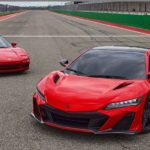 A first and second generation Acura NSX are shown on a racetrack.