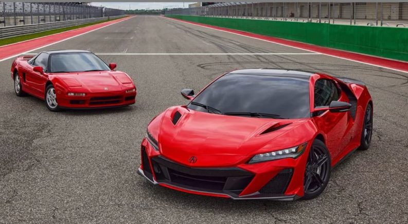 A first and second generation Acura NSX are shown on a racetrack.