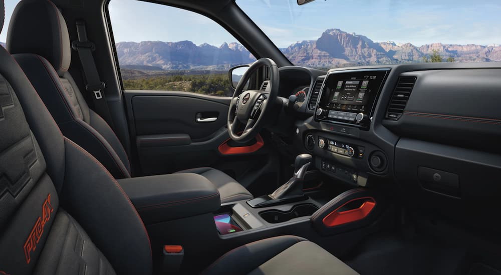 The black and red interior of a 2022 Nissan Frontier PRO-4X is shown after leaving a Nissan Frontier dealer.