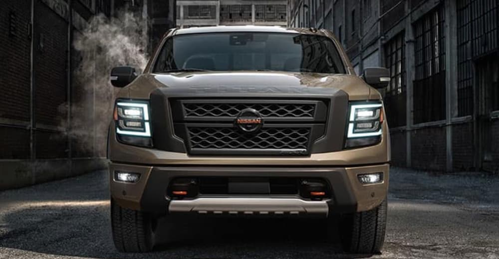 A tan 2020 Nissan Titan is shown from the front parked in an alley.