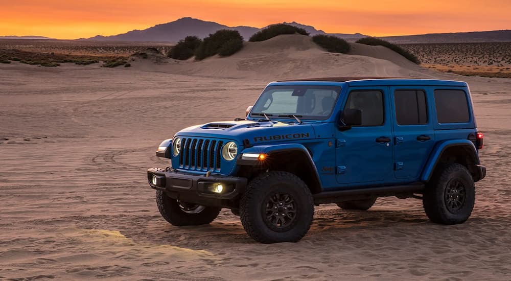 A blue 2021 Jeep Wrangler Rubicon 392 is shown parked in the desert during a sunset.