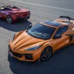 An orange and a maroon 2023 Chevy Corvette Z06 are shown from a high angle parked on pavement.
