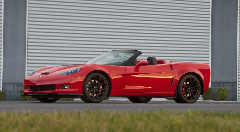 A red 2013 Chevy Corvette 427 is shown parked in front of a garage.