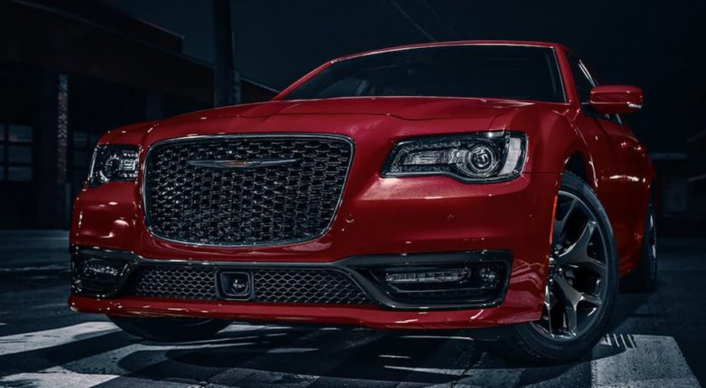 A red 2022 Chrysler 300 is shown parked at a Chrysler dealership.