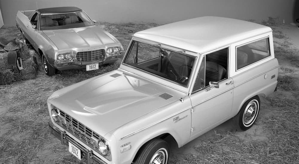 A grey 1972 Ford Bronco and Ranchero and shows parked inside a Ford dealership.