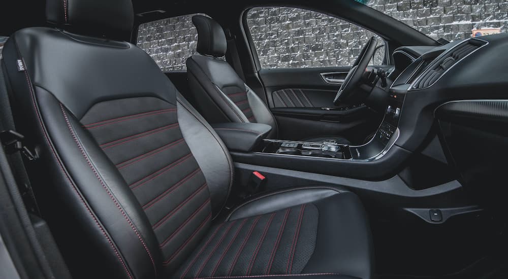 The black interior of a 2020 Ford Edge ST shows the front seats and steering wheel.