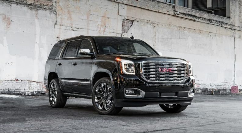 A black 2019 GMC Yukon Denali is shown parked after leaving a used GMC dealer.