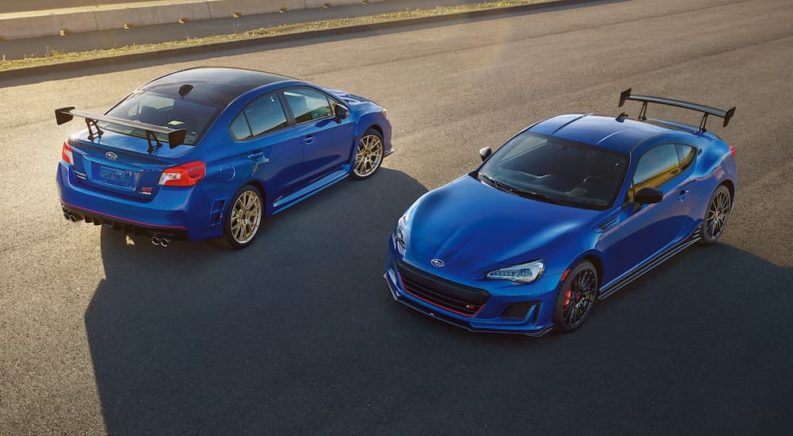 A blue 2018 Subaru WRX STI TypeRA and a blue 2018 Subaru BRZtS are shown facing opposite directions from a high angle after leaving a certified pre-owned Subaru dealer in Charlotte.