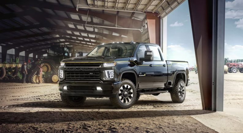 A black 2021 Chevy Silverado HD Carhartt Edition is shown from an angle inside a barn.