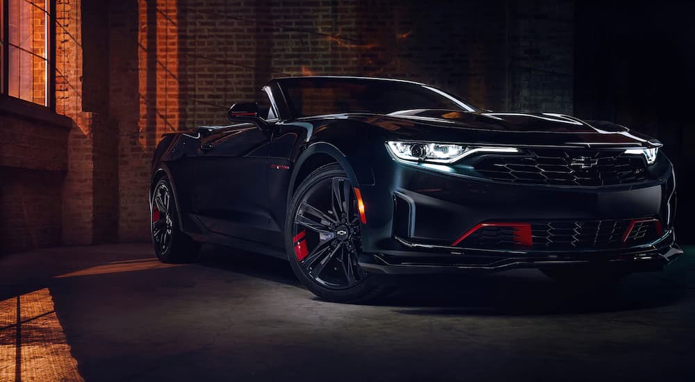 A black 2022 Chevy Camaro Redline is shown parked in a warehouse.