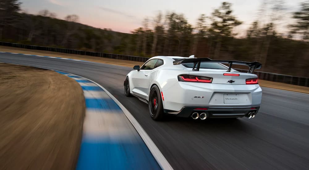 A white 2022 Chevy Camaro ZL1 is shown from the rear on a race track.