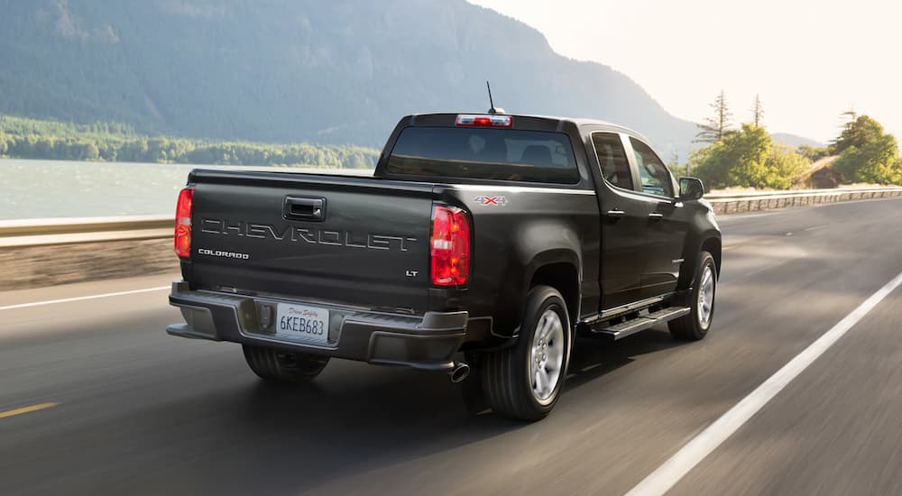 A black 2022 Chevy Colorado LT is shown from a rear angle driving on a highway.