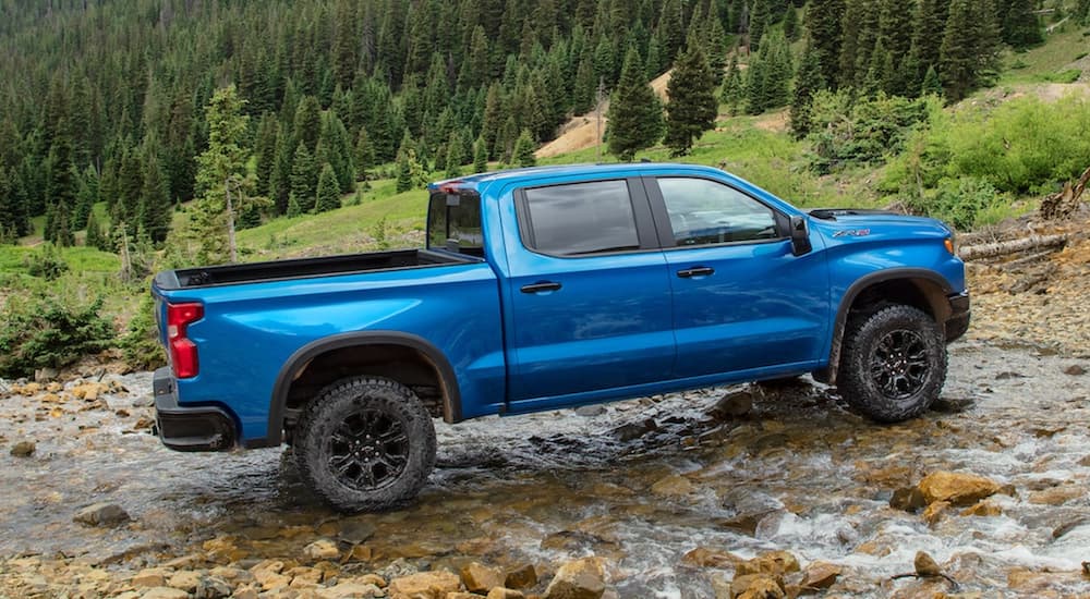 A blue 2022 Chevy Silverado 1500 ZR2 is shown from the side off-roading.