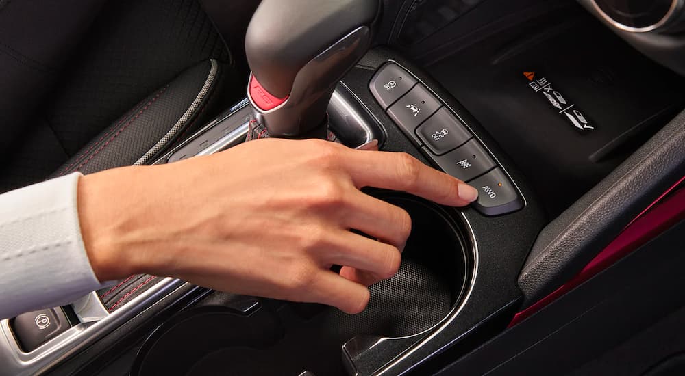 A close up shows a hand pressing the AWD button in a 2022 Chevy Trailblazer RS.