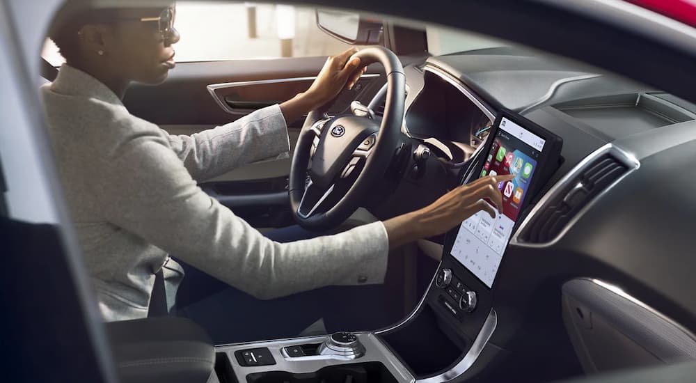 A woman is shown using the infotainment screen in a 2022 Ford Edge.