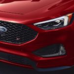 A close up shows the grille and headlights of a red 2022 Ford Edge ST.