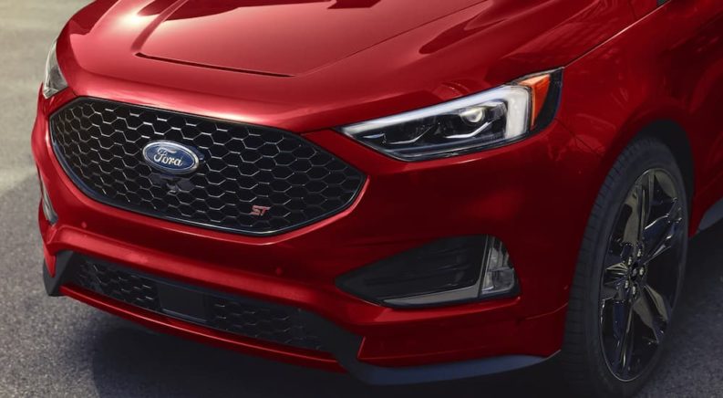 A close up shows the grille and headlights of a red 2022 Ford Edge ST.
