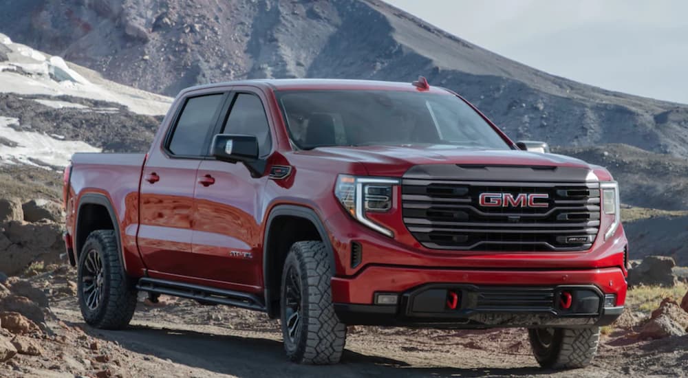 A red 2022 GMC Sierra 1500 is shown from the front parked in the mountains.