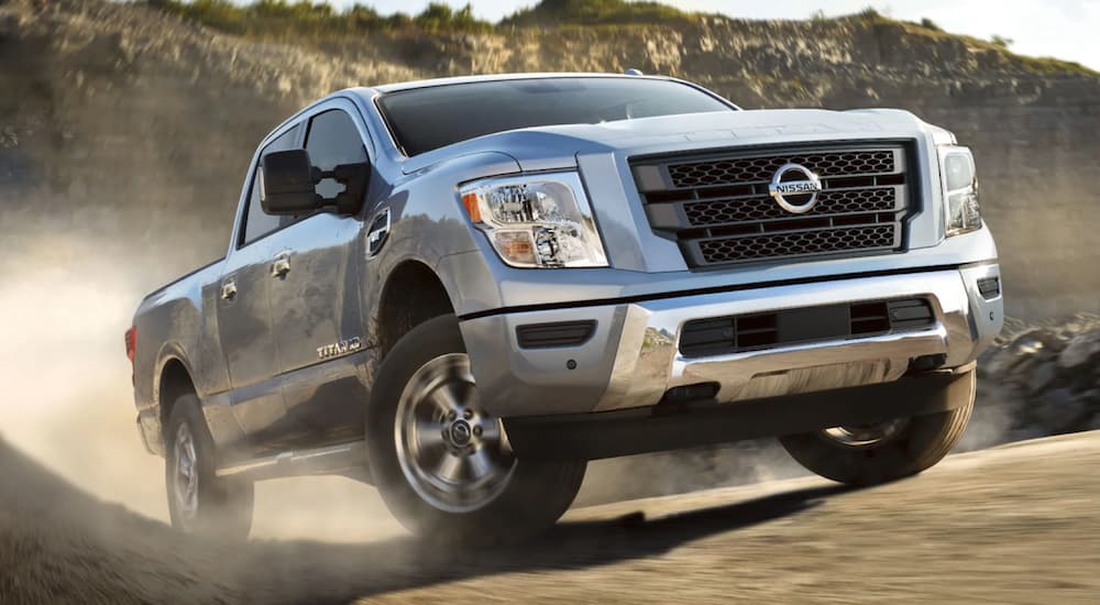 A silver 2022 Nissan Titan is shown from the front off-roading in a desert.
