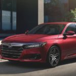 A red 2022 Honda Accord Hybrid Touring is shown from the side parked on a city street.