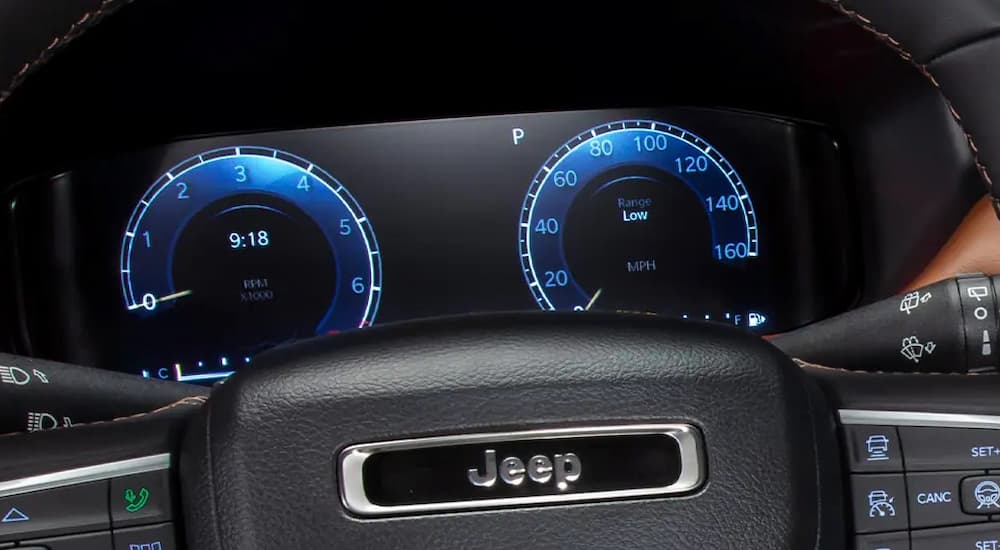 A close up shows the dashboard and steering wheel of a 2022 Jeep Compass.