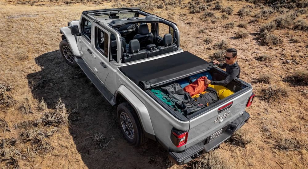 A silver 2022 Jeep Gladiator is shown with a full payload in a desert.
