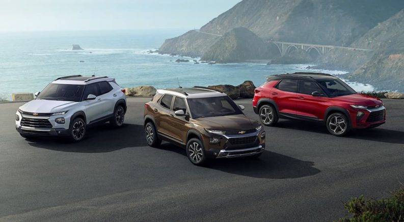 A white 2022 Trailblazer, a bronze ACTIV, and a red RS are shown overlooking the ocean.