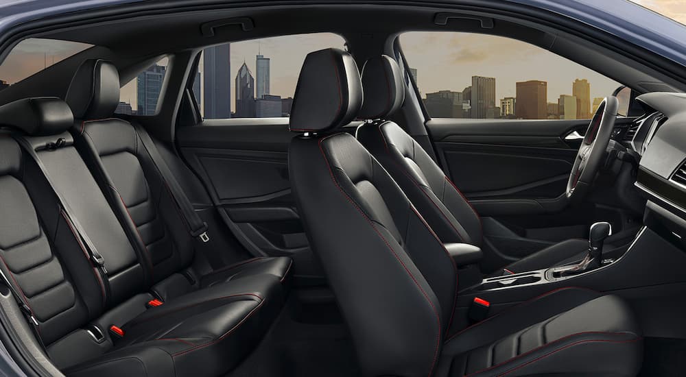 The black interior of a 2022 Volkswagen Jetta GLI shows the front and back seats.