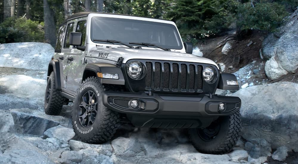 A silver 2020 Jeep Wrangler Willys is shown off-roading after visiting a Jeep car dealer.