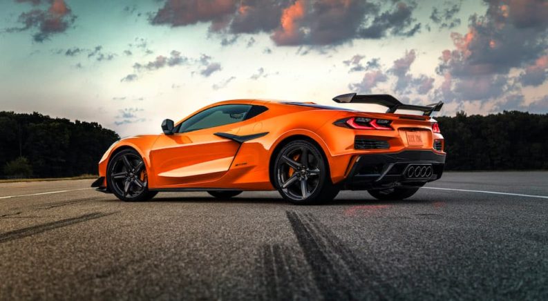 An orange 2023 Chevy Corvette Z06 is shown from the side on a cloudy day.