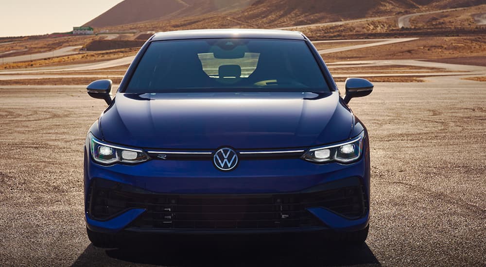 A blue 2022 Volkswagen Golf R is shown from the front parked after leaving a Volkswagen dealer.