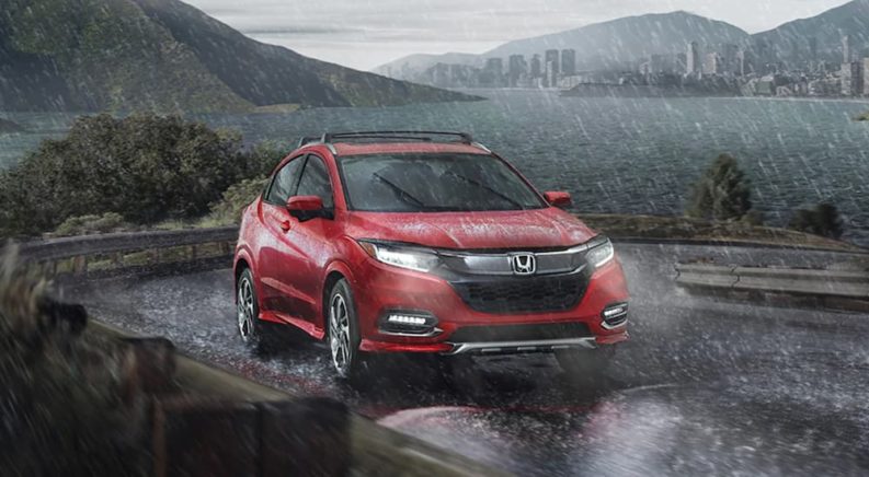 A red 2022 Honda HRV is shown driving in the rain during a comparison of the 2022 Honda HR-V and 2022 Jeep Renegade.