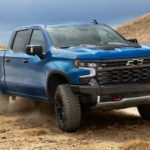 A blue 2022 Chevy Silverado 1500 ZR2 is shown from the front off-roading in a desert.