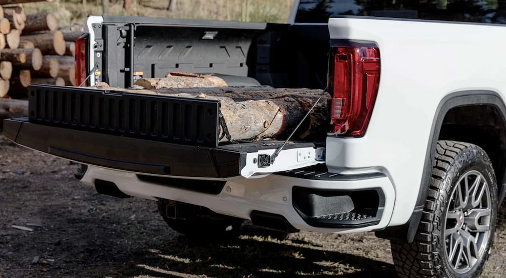 The bed of a white 2022 GMC Sierra 1500 Limited AT4 shows logs and the MultiPro Tailgate.