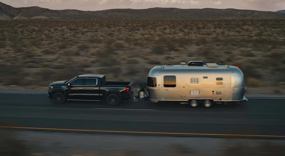 A black 2022 GMC Sierra 1500 is shown from the side towing an airstream trailer after winning a 2022 GMC Sierra 1500 vs 2022 Ford F-150 comparison.