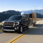 A black 2022 GMC Yukon is shown towing a silver Airstream camper.