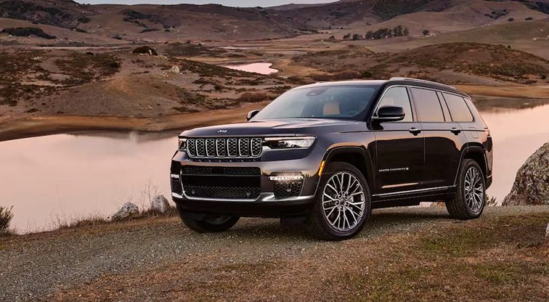 A black 2022 Jeep Grand Cherokee L is shown parked next to a lake after winning a 2022 Jeep Grand Cherokee L vs 2022 Nissan Pathfinder showdown.