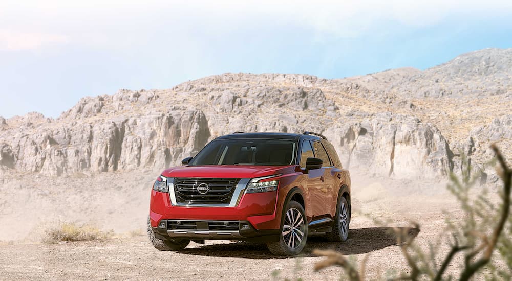 A red 2022 Nissan Pathfinder is shown parked in the desert.