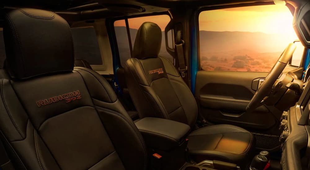 The black interior of a 2022 Jeep Wrangler Rubicon 392 shows the front seats.