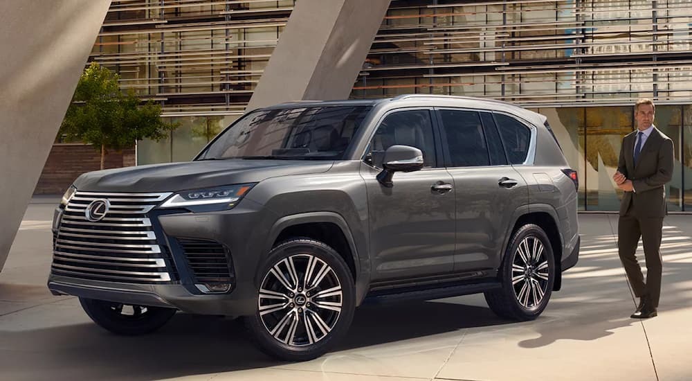 A grey 2022 Lexus LX is shown from the side at an angle parked in a modern urban setting.