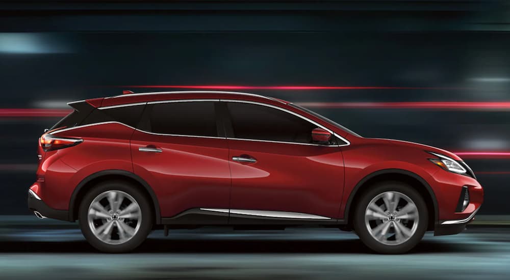 A red 2022 Nissan Murano is shown from the side driving on an open road.