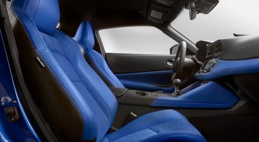 The blue interior of a 2023 Nissan Z is shown from the passenger door looking in.