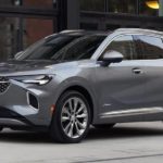 A grey 2022 Buick Envision Avenir is shown on a city street after visiting a Buick dealership.